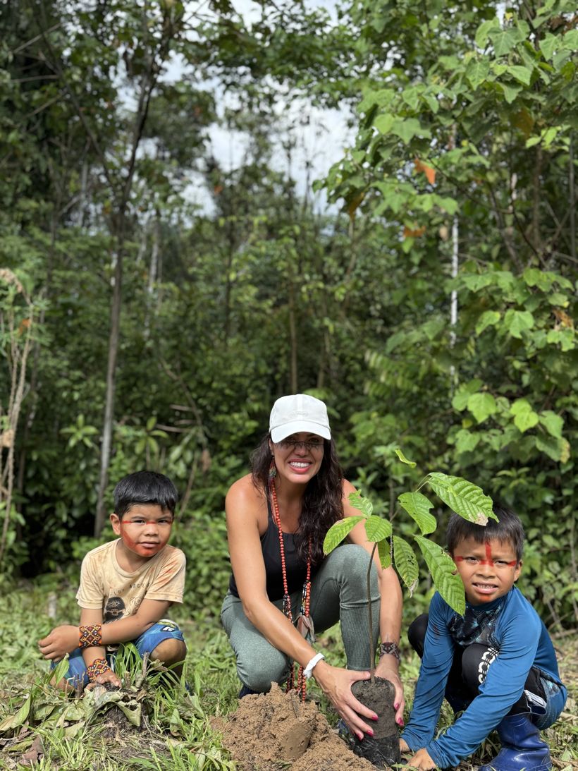 Márcia planting a cacao seedling with two Yawanawá boys